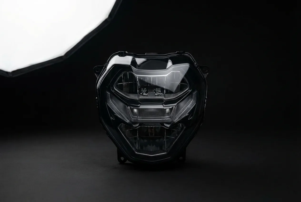 Gros plan iconique et minimaliste du phare avant à LED de la nouvelle BMW S1000R 2025, sur fond noir en studio.